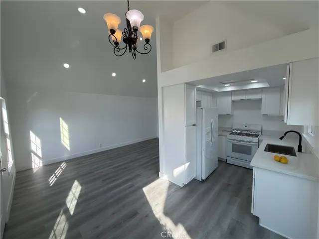 a kitchen with a refrigerator chandelier and a stove