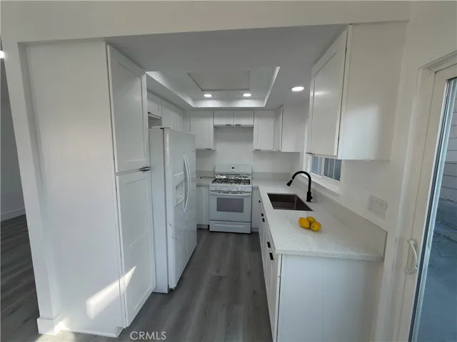 a kitchen with a refrigerator a sink and cabinets
