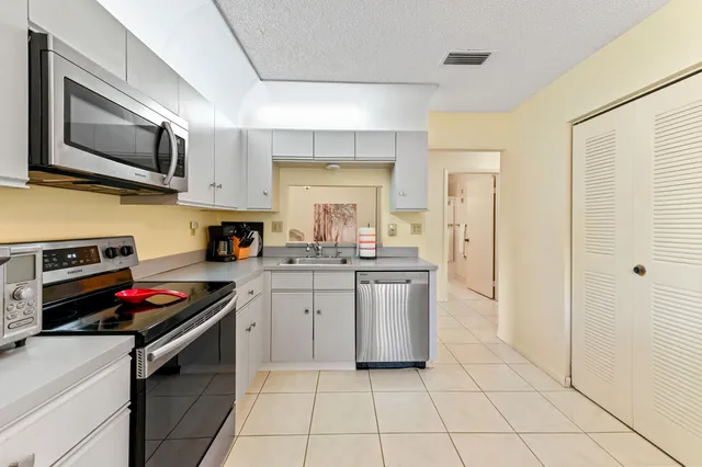 a kitchen with stainless steel appliances a stove a sink and a microwave