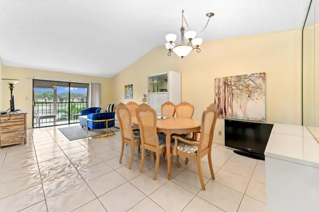 a view of a dining room with furniture a chandelier and wooden floor