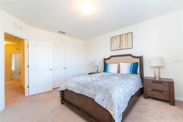 a bedroom with a bed and a lamp on the dresser