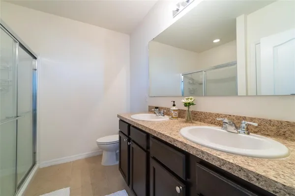 a bathroom with a granite countertop sink a toilet and a mirror