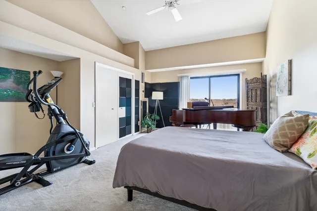 a bedroom with a bed gym equipment and view of living room