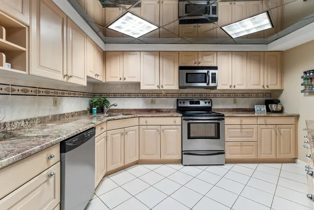 a kitchen with granite countertop a sink stainless steel appliances and cabinets