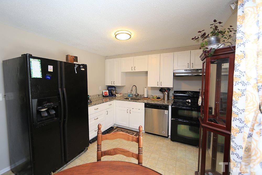 7705 Mourning Dove Road Raleigh, NC 27615 - Photo 4 of 14 a kitchen with a refrigerator and a stove