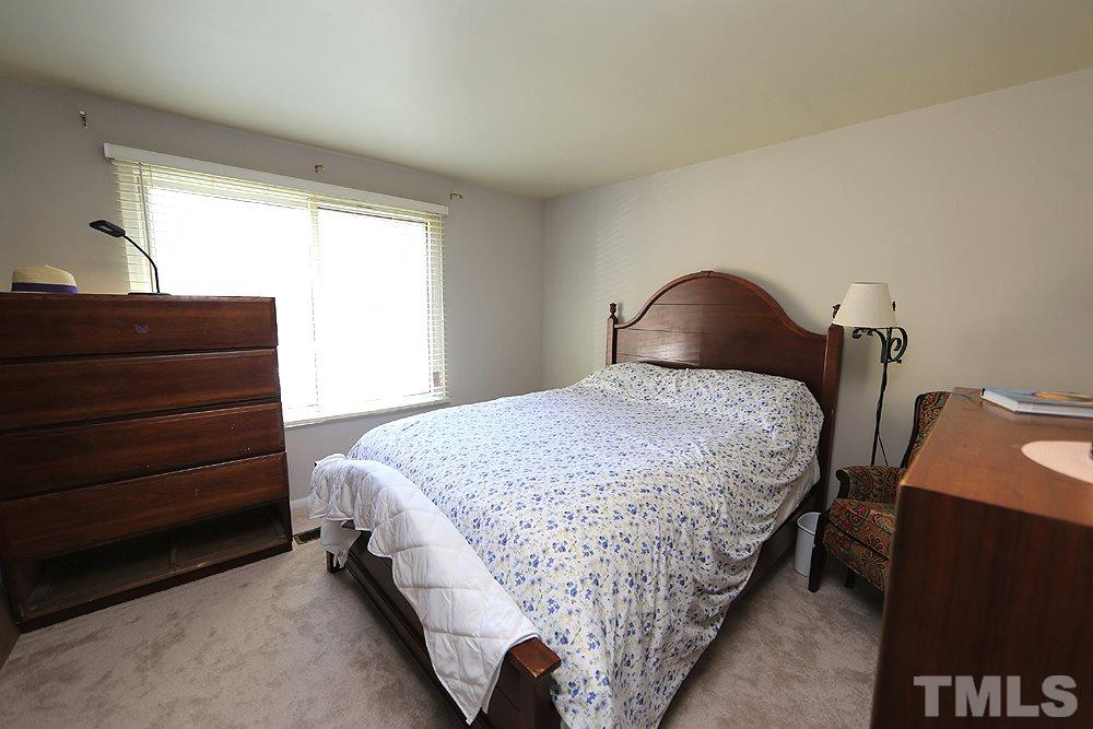 7705 Mourning Dove Road Raleigh, NC 27615 - Photo 5 of 14 a bedroom with a bed and lamp