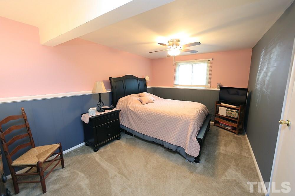 7705 Mourning Dove Road Raleigh, NC 27615 - Photo 8 of 14 a bedroom with a bed and a chandelier
