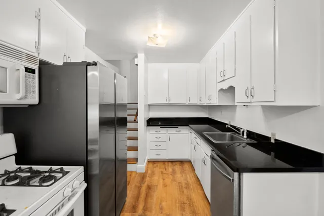 a bathroom with a granite countertop toilet and a sink