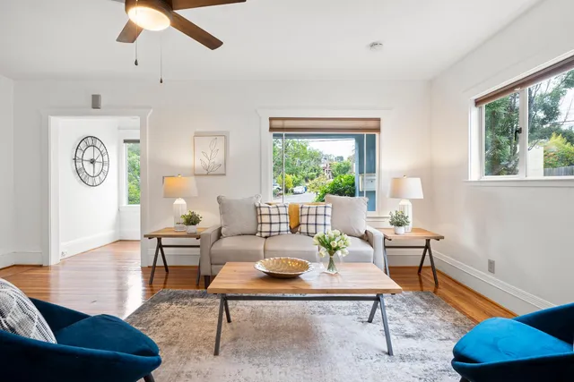 a living room with furniture a fireplace and a large window