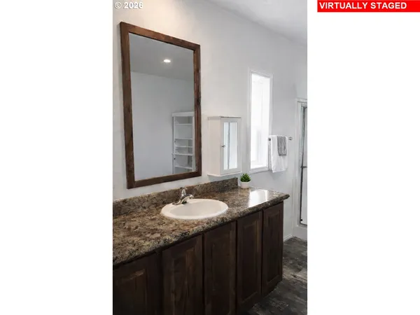a bathroom with a granite countertop sink and a mirror