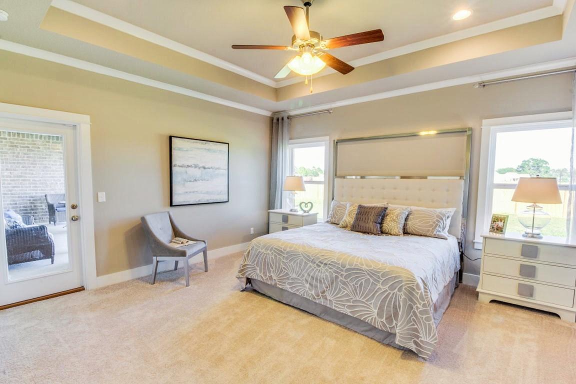 329 Merlin Court Crestview, FL 32539 - Photo 7 of 16 a bedroom with a large bed a chandelier and windows