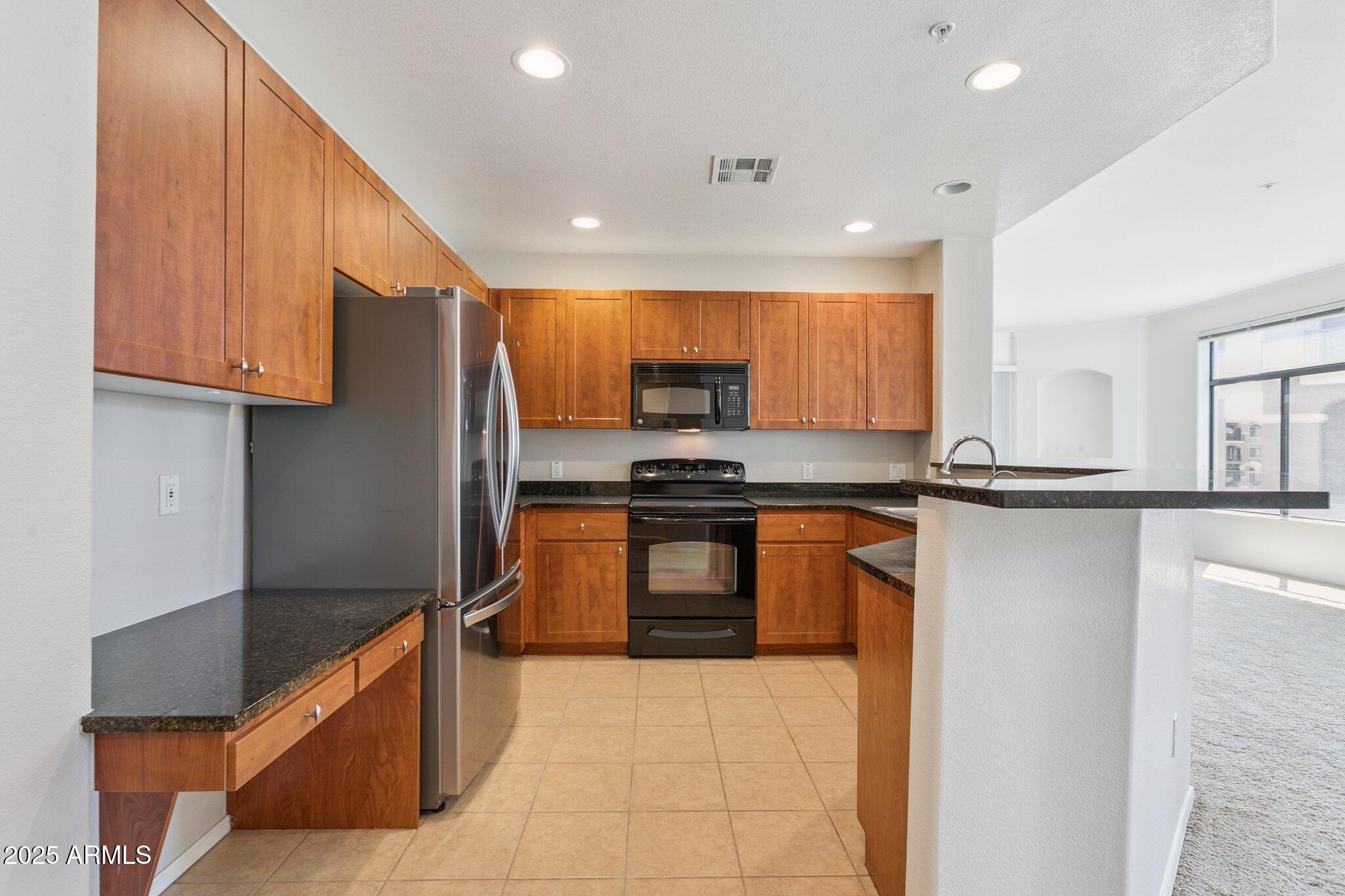 11640 North Tatum Boulevard, Unit 2079 Phoenix, AZ 85028 - Photo 19 of 48 a kitchen with stainless steel appliances granite countertop a refrigerator and a stove top oven
