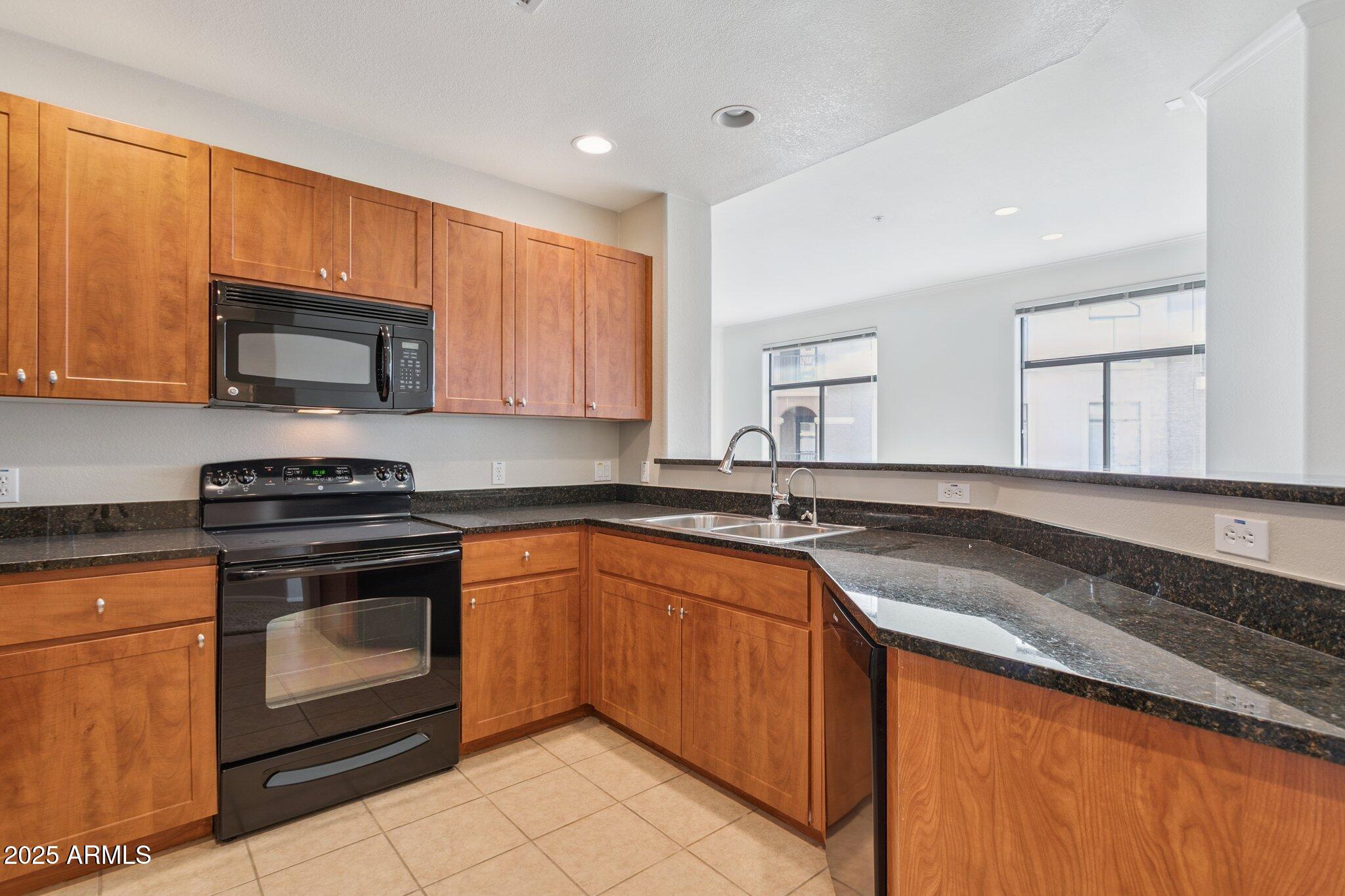 11640 North Tatum Boulevard, Unit 2079 Phoenix, AZ 85028 - Photo 20 of 48 a kitchen with stainless steel appliances granite countertop a stove a sink and a microwave