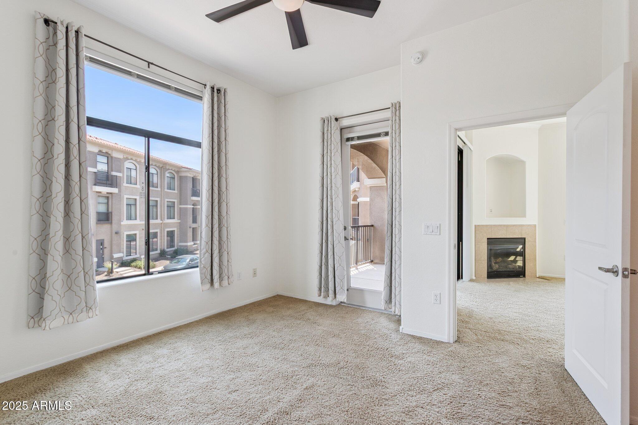11640 North Tatum Boulevard, Unit 2079 Phoenix, AZ 85028 - Photo 23 of 48 an empty room with chandelier fan and windows