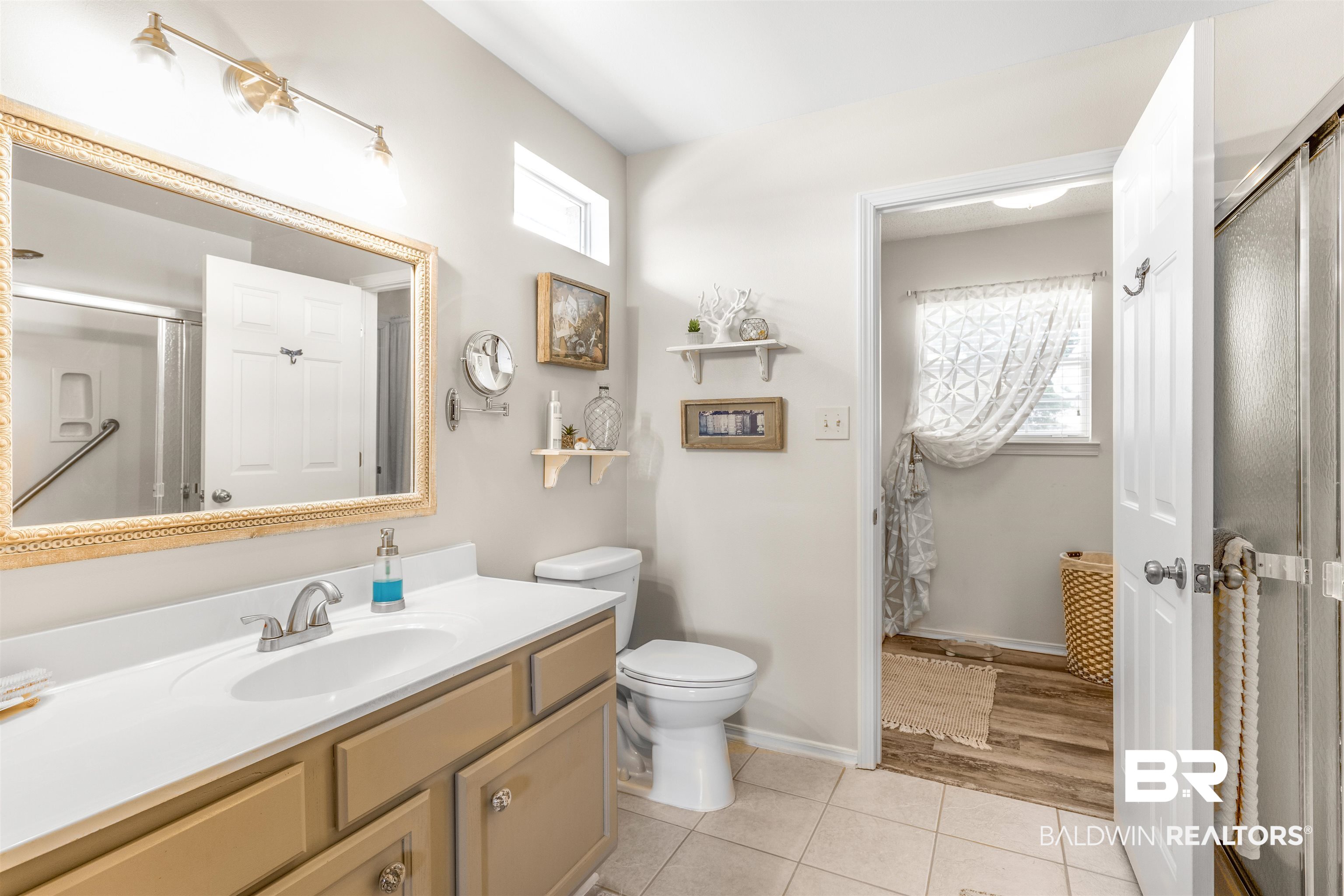 518 Ariel Avenue Foley, AL 36535 - Photo 18 of 47 Bathroom with ceramic tile flooring, a healthy amount of sunlight, toilet, and vanity and stand up shower.