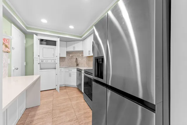 a kitchen with white cabinets and stainless steel appliances
