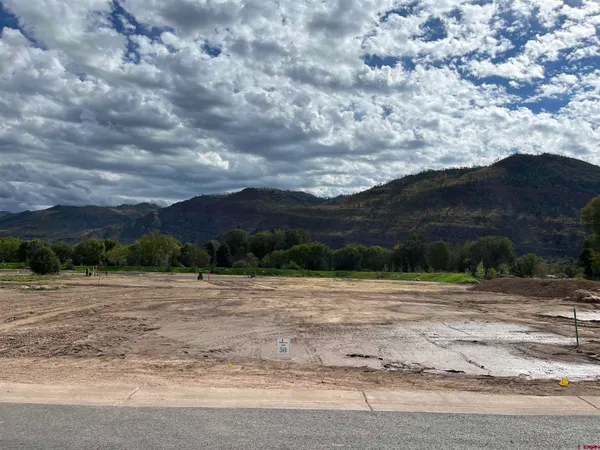 a view of dirt field with mountain