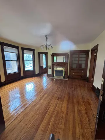 wooden floor fireplace and windows in an empty room