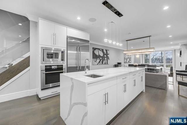 1234 River Road Edgewater, NJ 07020 - Photo 6 of 29 a kitchen with white cabinets and stainless steel appliances