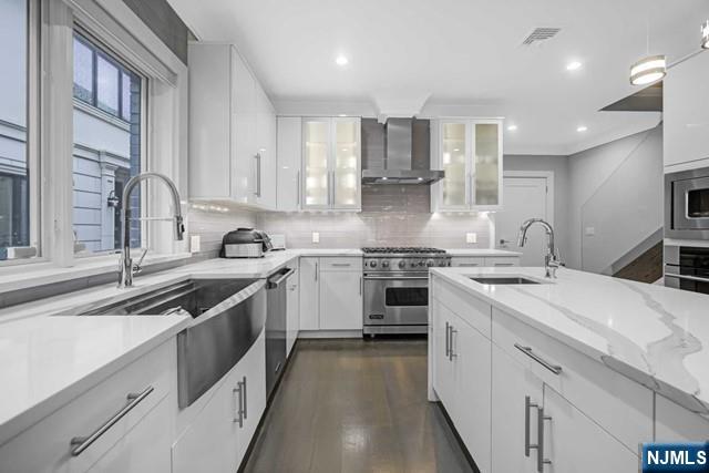 1234 River Road Edgewater, NJ 07020 - Photo 7 of 29 a kitchen with white cabinets and appliances