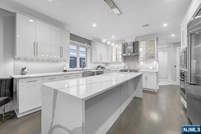 1234 River Road Edgewater, NJ 07020 - Photo 8 of 29 a large kitchen with kitchen island a sink stainless steel appliances and white cabinets
