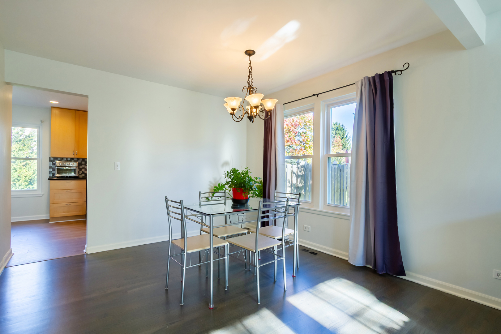1734 Somerfield Lane Crystal Lake, IL 60014 - Photo 7 of 25 a dining room with wooden floor a chandelier a glass table and chairs