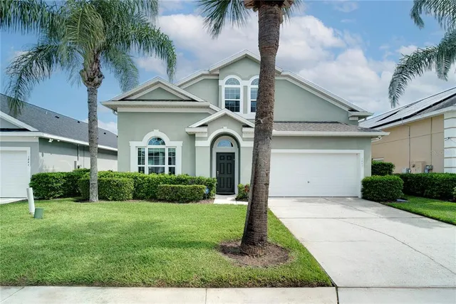 a front view of a house with a yard and potted plants