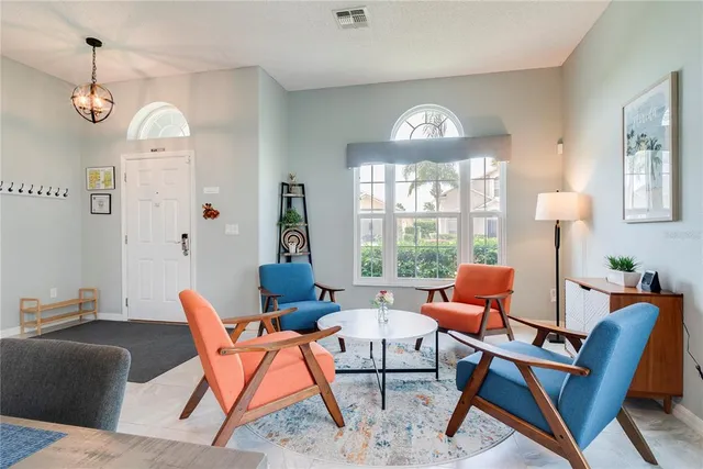 a dining room with furniture a chandelier and wooden floor