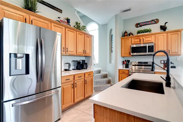 a kitchen with stainless steel appliances a stove sink refrigerator and cabinets