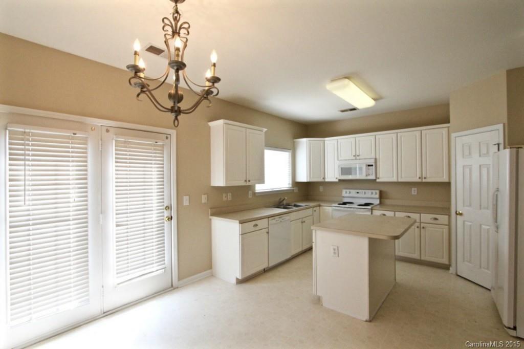 9738 Bailey Road, Unit 170 Cornelius, NC 28031 - Photo 5 of 10 a kitchen with a stove a sink a chandelier cabinetry and kitchen view