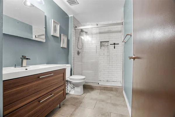 a bathroom with a sink a toilet and shower