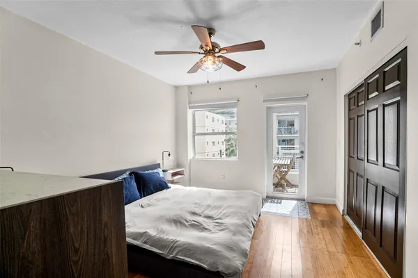 a bedroom with a bed cabinets and a window