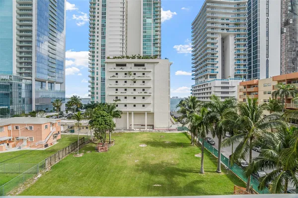 a view of a tall building next to a yard