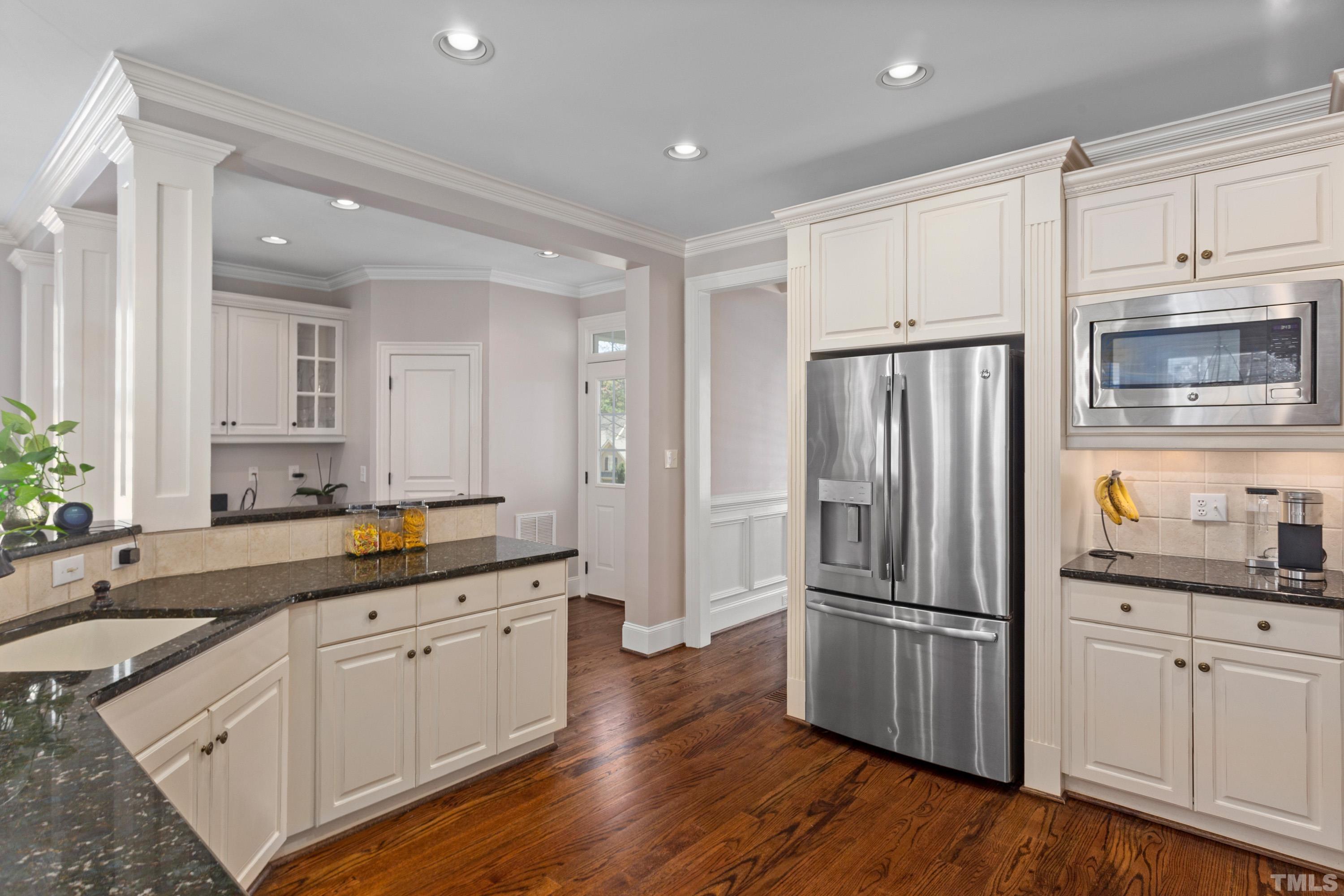 4324 Summer Brook Drive Apex, NC 27539 - Photo 12 of 70 a kitchen with granite countertop a refrigerator a sink and white cabinets