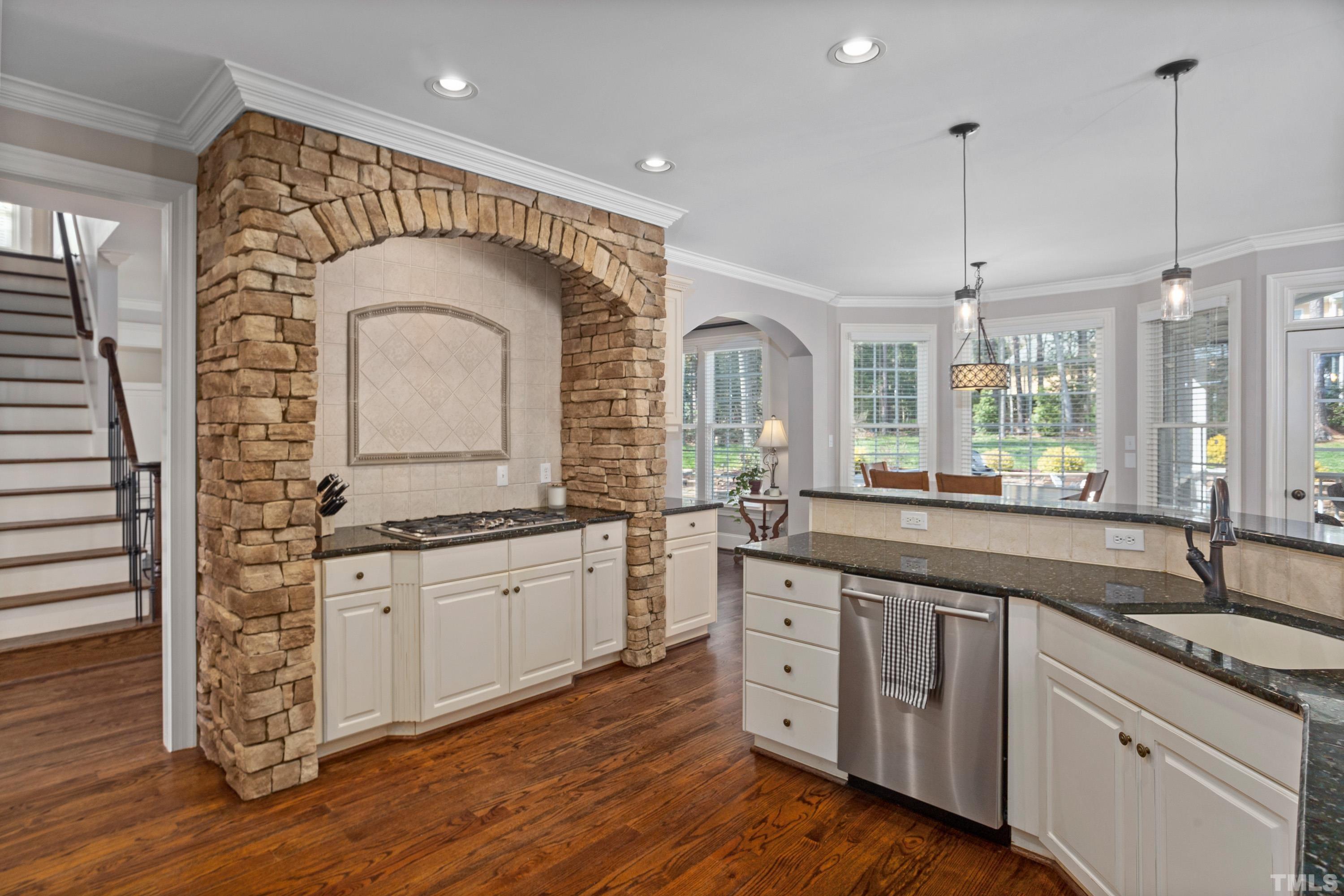4324 Summer Brook Drive Apex, NC 27539 - Photo 13 of 70 a kitchen with stainless steel appliances granite countertop a sink and cabinets with wooden floor