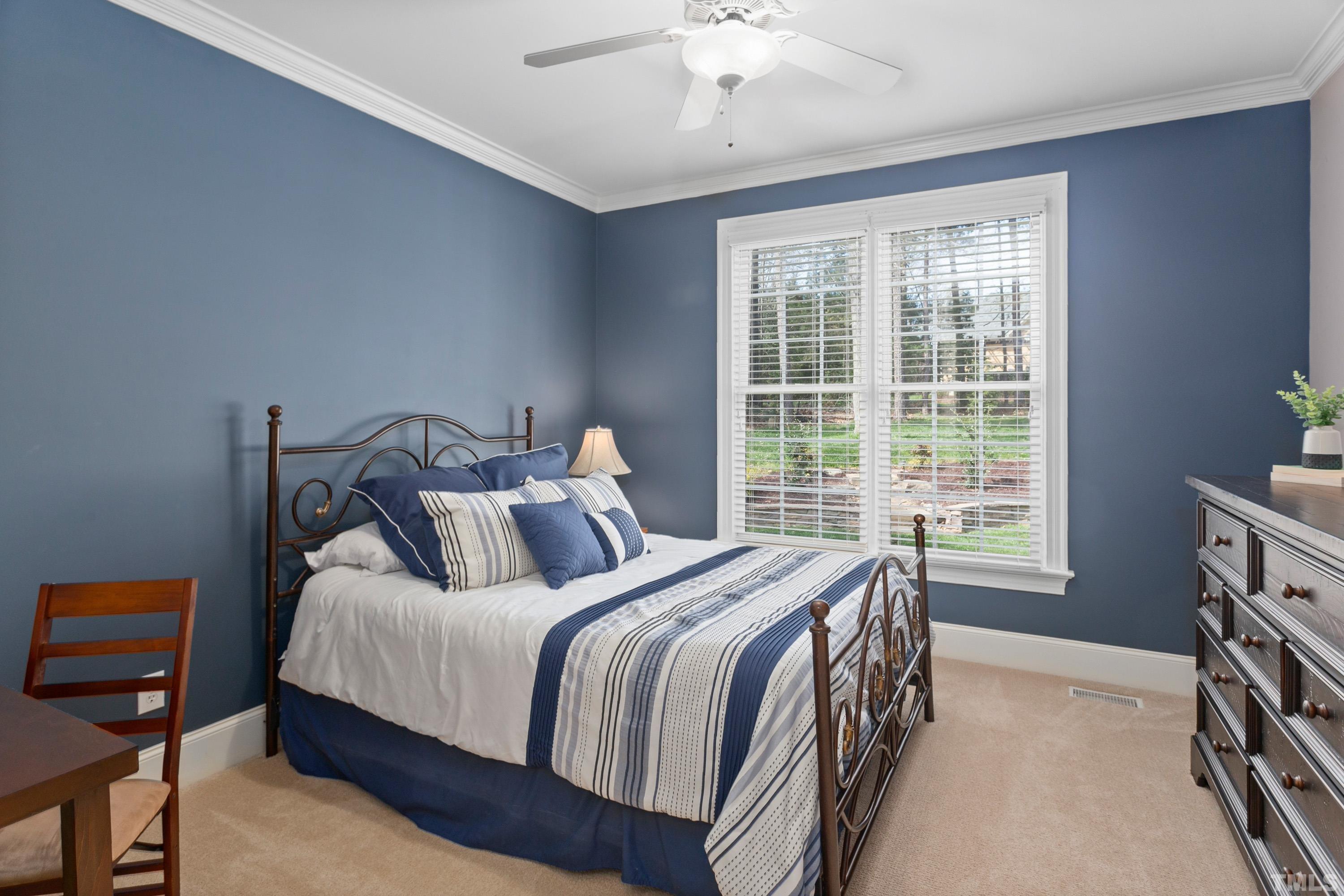 4324 Summer Brook Drive Apex, NC 27539 - Photo 18 of 70 a bedroom with a bed a chandelier and a window