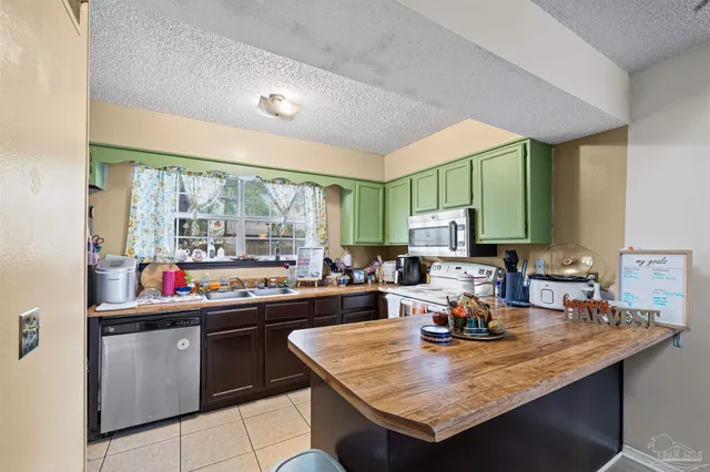 a kitchen with a sink a counter top space and stainless steel appliances