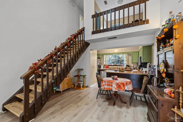 a living room with furniture and a dining table with wooden floor