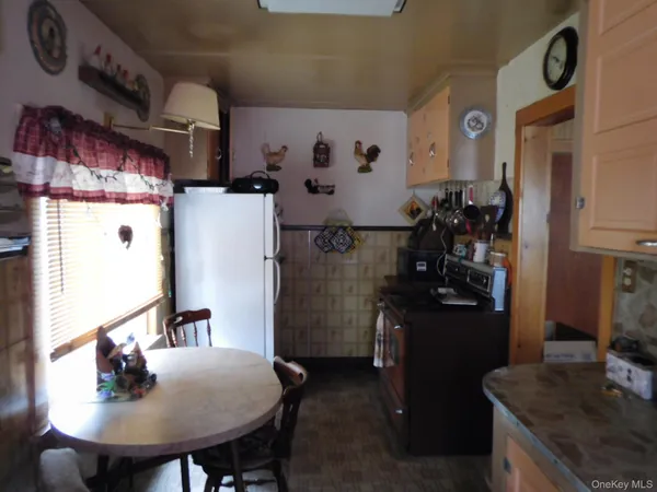 a kitchen with refrigerator and dining table