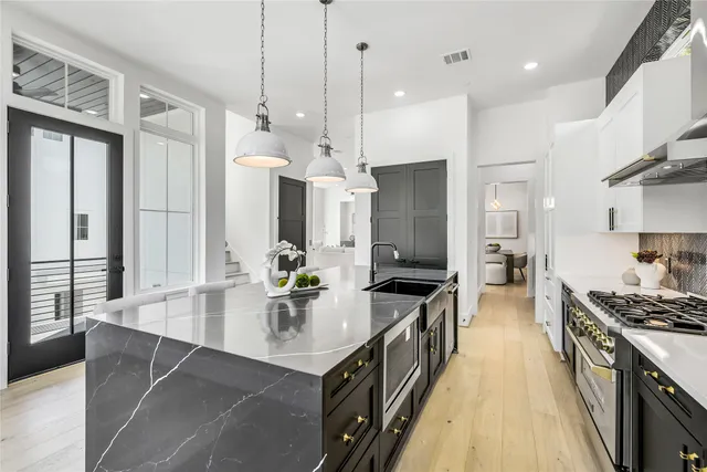 a kitchen with kitchen island a large counter top space a sink stainless steel appliances and cabinets