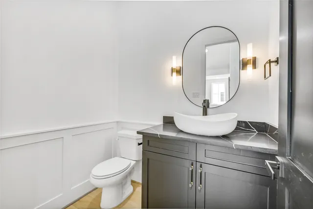 a bathroom with a toilet a sink and mirror