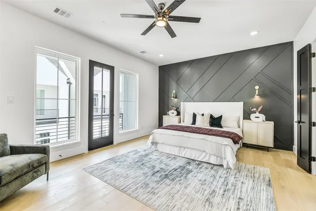 a spacious bedroom with a large bed and a chandelier