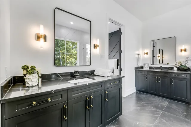 a bathroom with a granite countertop sink and a mirror