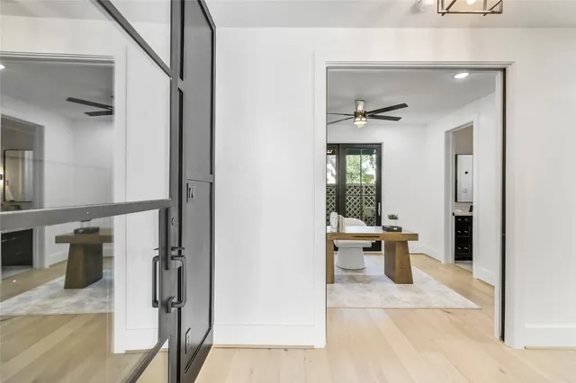 a view of a hallway with wooden floor and a living room