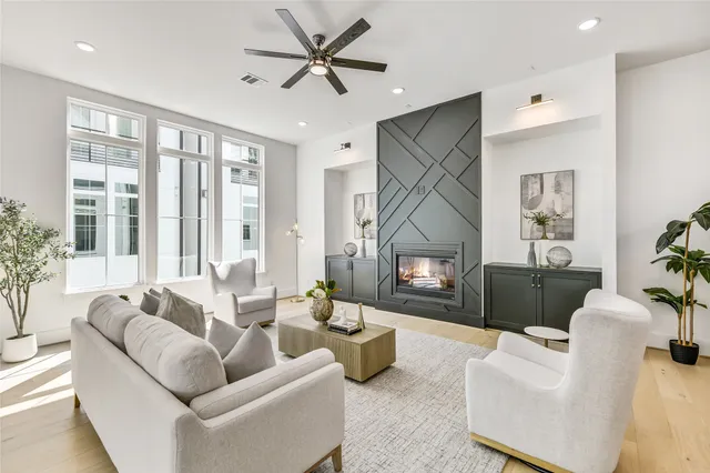 a living room with furniture a large window and a fireplace