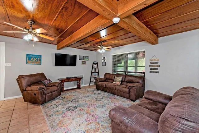 a living room with furniture a ceiling fan and a window