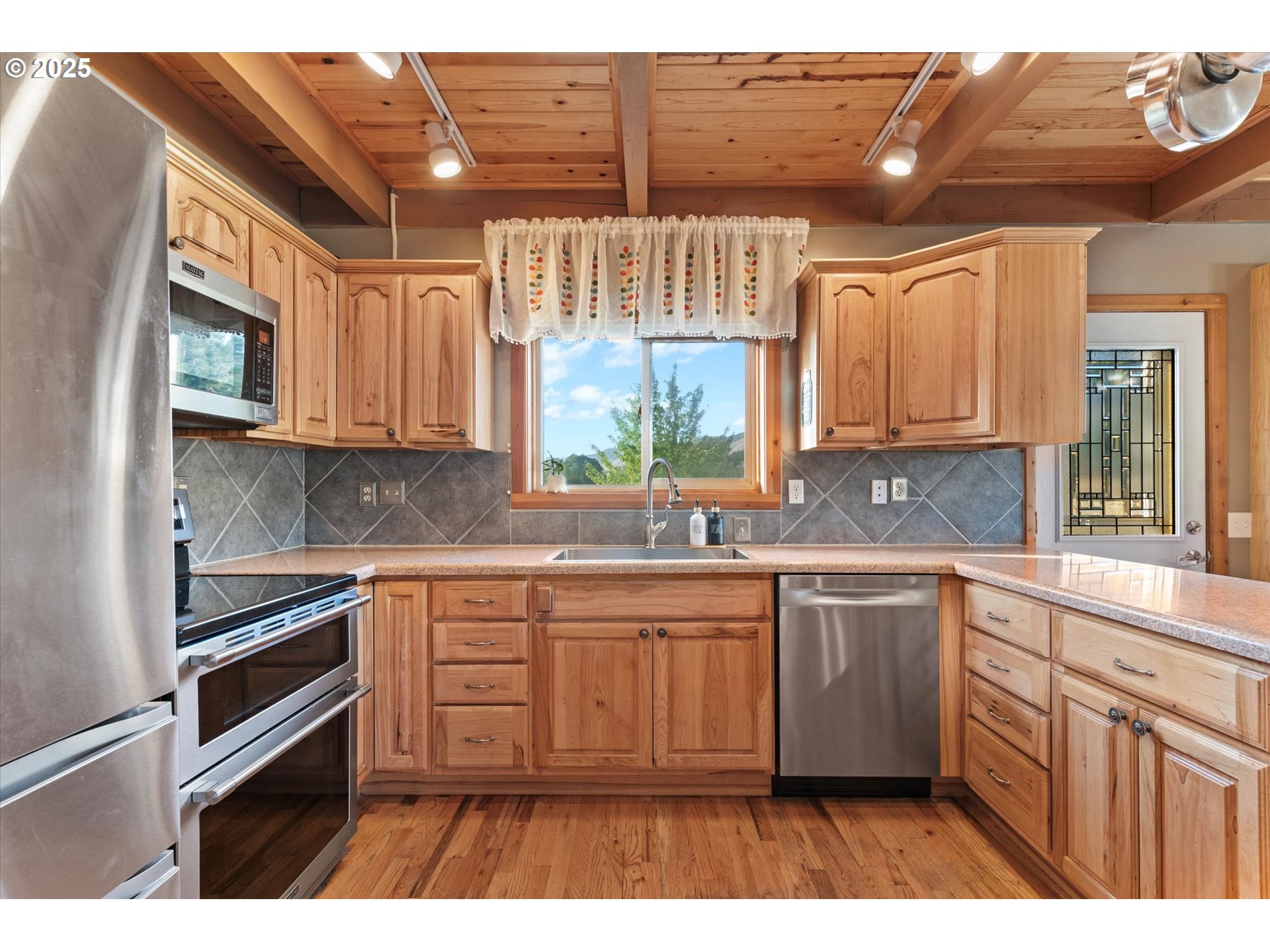 1008 Foster Street Cove, OR 97824 - Photo 14 of 33 a kitchen with stainless steel appliances kitchen island granite countertop a sink a stove a microwave a counter space and cabinets