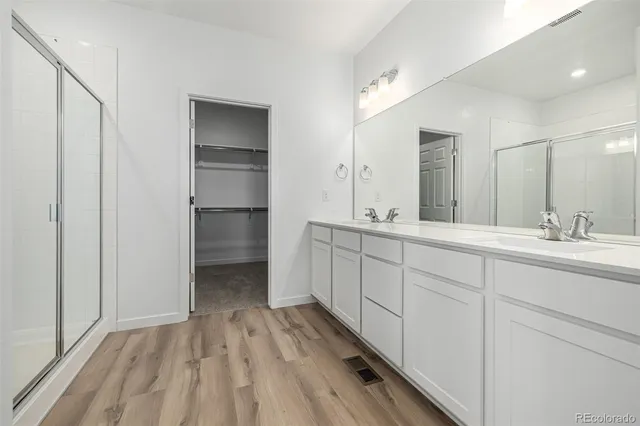 a spacious bathroom with a double vanity sink and mirror