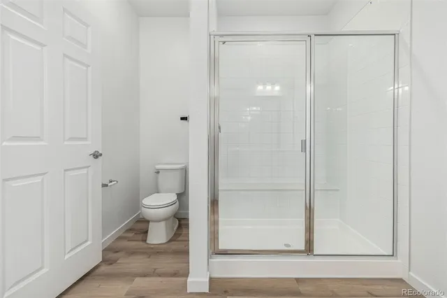 a bathroom with a granite countertop toilet and a shower
