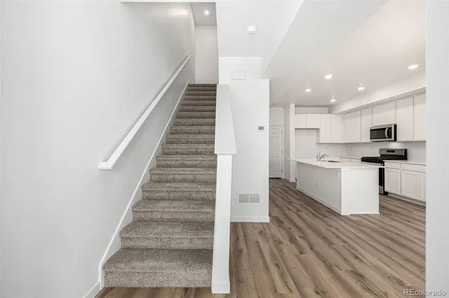 a view of kitchen with sink microwave and refrigerator